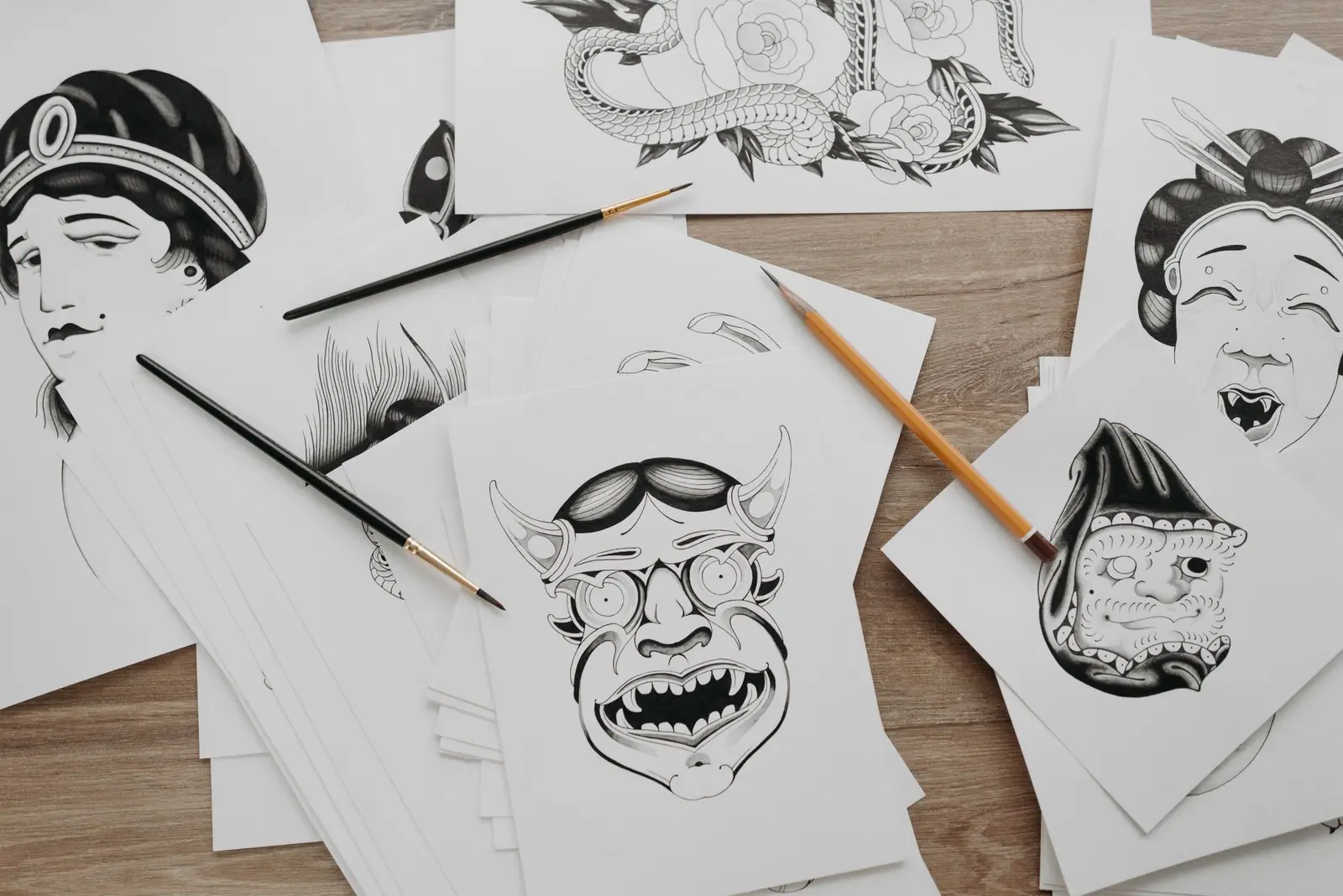Traditional tattoo flash drawings on paper with brushes and pencils