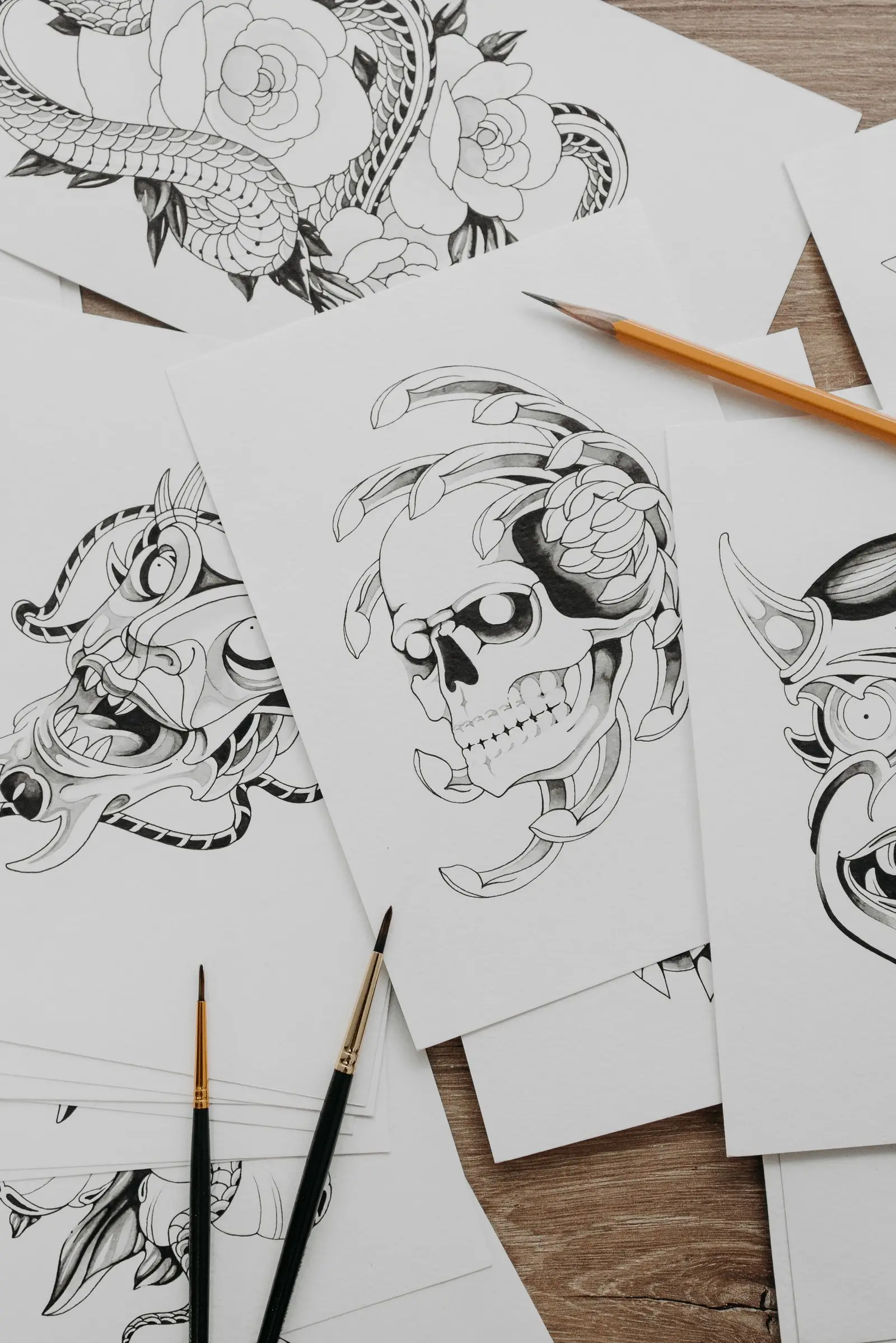 Stack of skull and floral tattoo designs