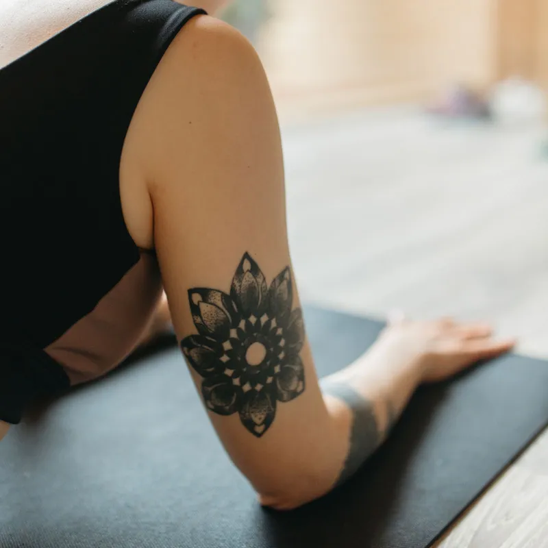 Mandala flower tattoo shaded with dots on an upper arm