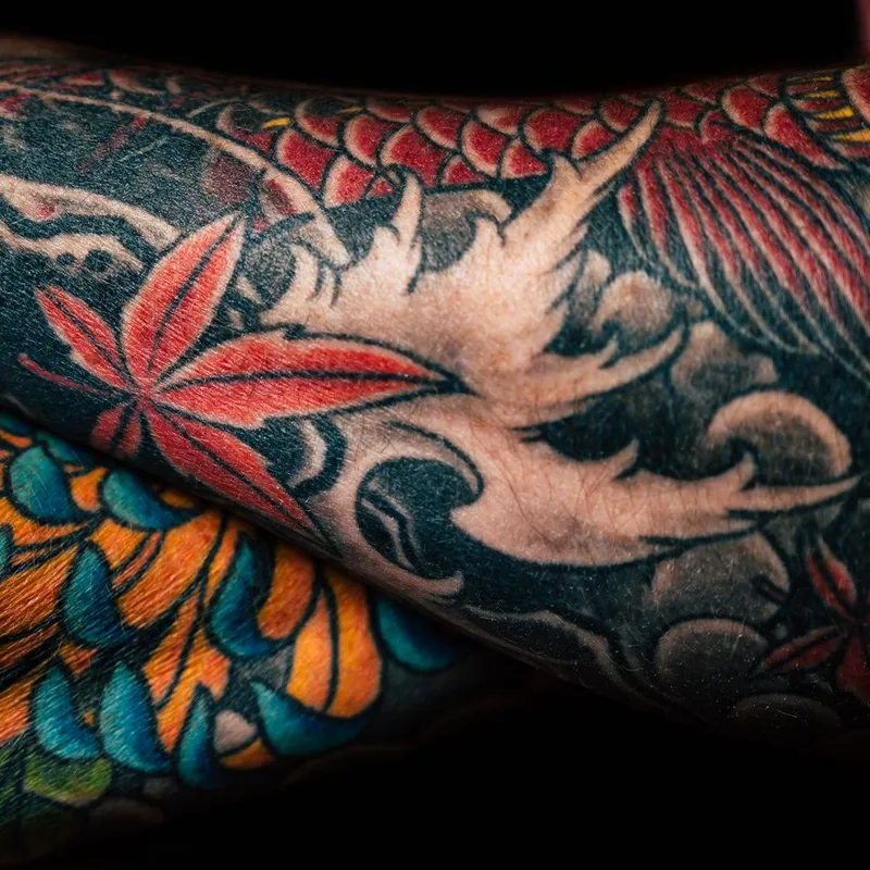 Japanse sleeve met een koi, esdoornbladeren, golven en een donkere achtergrond