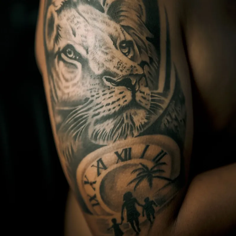 Realistic black and grey lion tattoo with a clock on an upper arm